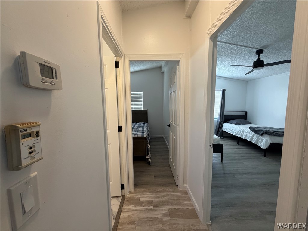 1910 Rio Grande Road Bullhead City, AZ 86442 - Photo 19 of 29 Hallway featuring wood-finish flooring, white walls, and white trim