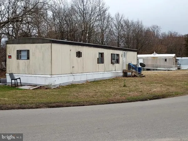 a backyard of a house with yard and trees in the background