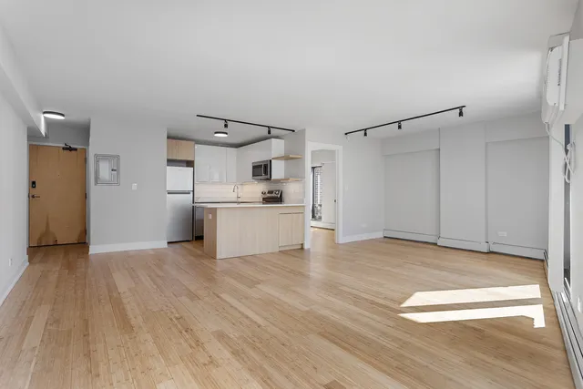 a view of a kitchen with a sink and a refrigerator
