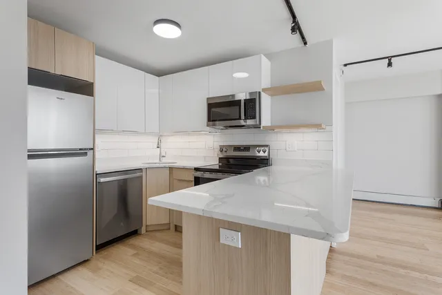 a kitchen with a refrigerator a microwave a sink and cabinets