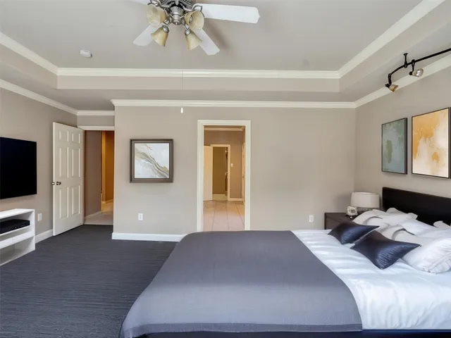 a bedroom with a large bed and a chandelier