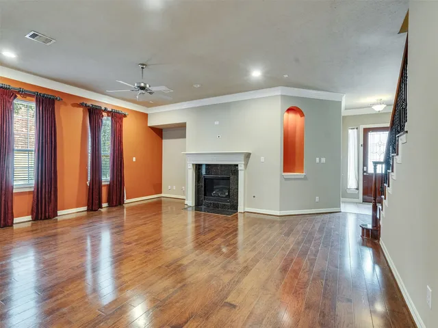 an empty room with wooden floor and a fireplace