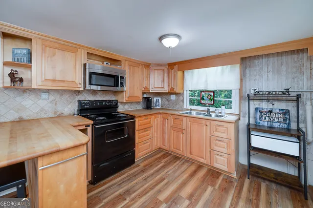 a kitchen with stainless steel appliances granite countertop a stove a sink and a microwave