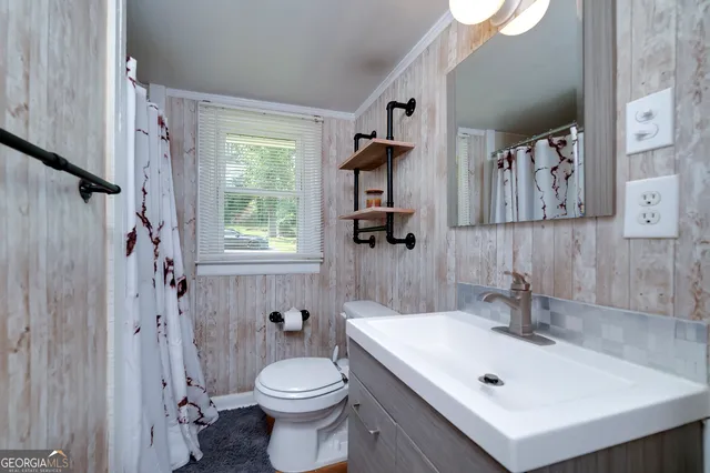 a bathroom with a sink a toilet and shower curtain