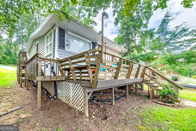 a view of a chairs setting on the deck in front of a house