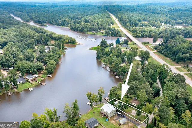 an aerial view of a house with a yard and lake view
