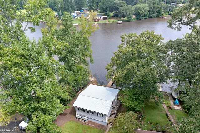 an aerial view of a house with a yard and lake view