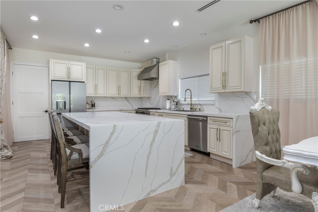 9728 Rhea Avenue Northridge, CA 91324 - Photo 10 of 36 a kitchen with a table chairs sink and cabinets