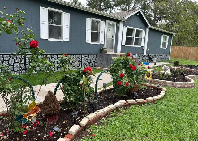 a view of a house with a yard and garden