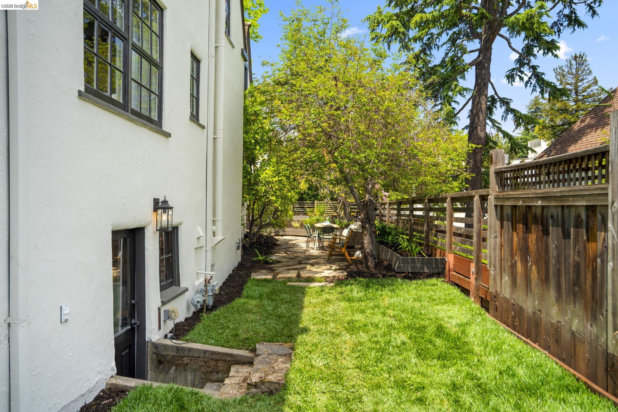 1087 Hubert Road Oakland, CA 94610 - Photo 56 of 67 Expansive side yard featuring a manicured lawn, flagstone path, and mature trees