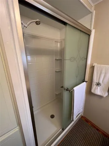 a bathroom with a glass door shower and a sink