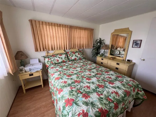 a bedroom with a bed and large windows