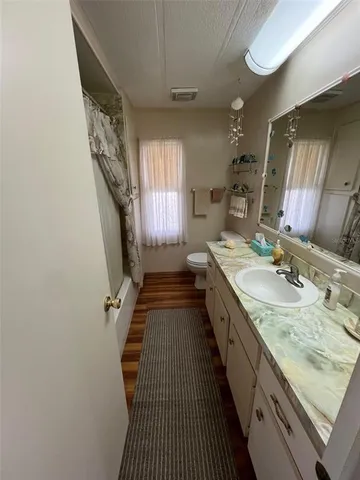 a bathroom with a granite countertop double vanity sink and a mirror