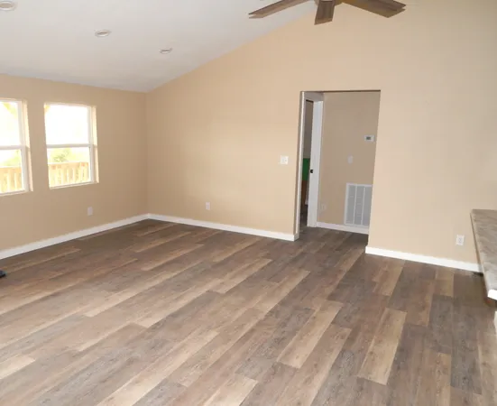 wooden floor in an empty room with a window
