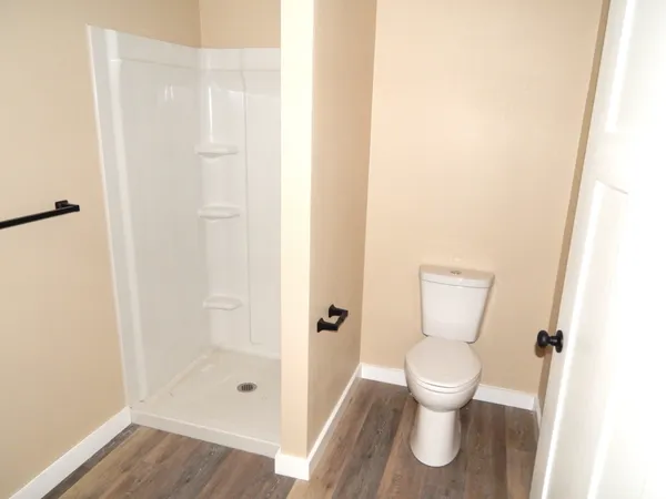a white toilet sitting next to a shower