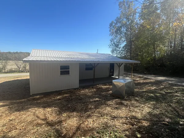 a view of a house with backyard and sitting area