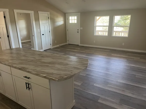 an empty room with wooden floor and window