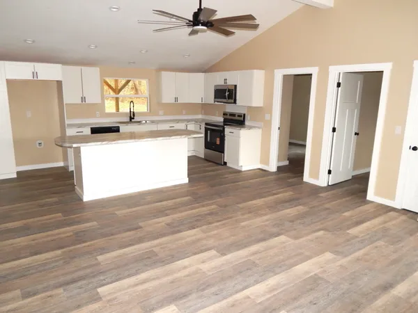 a kitchen with stainless steel appliances wooden floor and a refrigerator