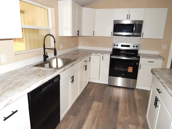 a kitchen with granite countertop a sink and steel appliances