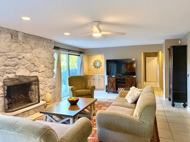 a living room with furniture a fireplace and a flat screen tv