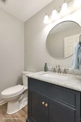 a bathroom with a granite countertop toilet sink mirror and vanity