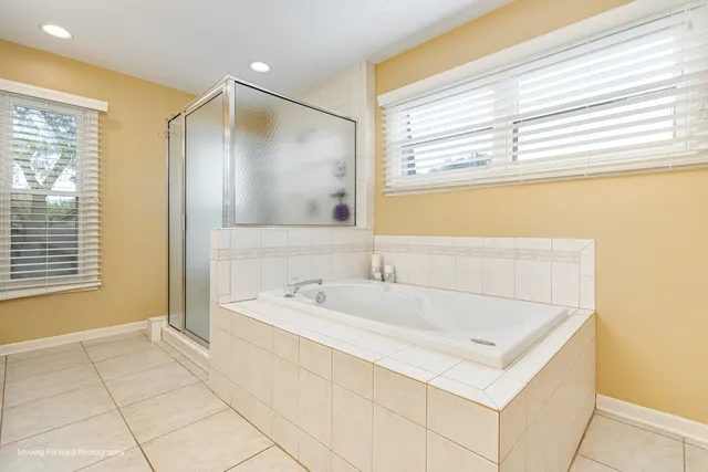 a bathroom with a tub a sink and a large mirror
