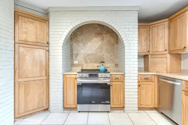 a kitchen with granite countertop a stove top oven and cabinets