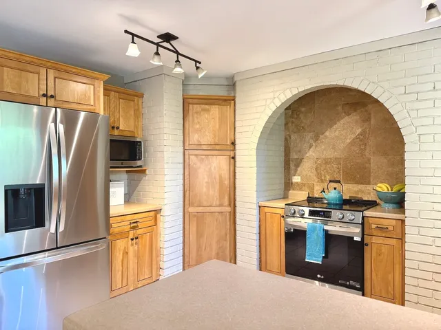 a kitchen with stainless steel appliances granite countertop a stove a refrigerator and a sink