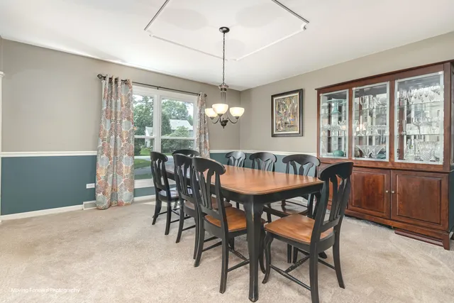 a dining room with furniture a chandelier and window