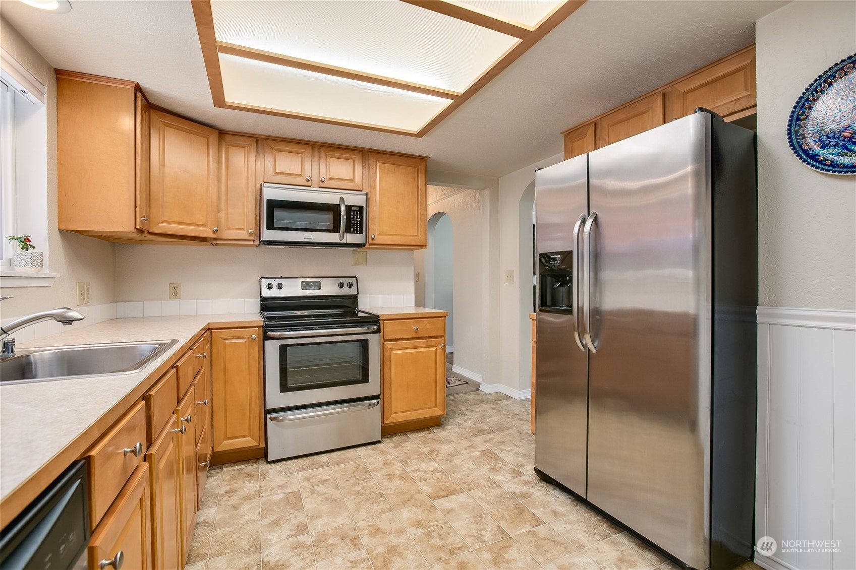 1124 Southwest Sunset Boulevard Renton, WA 98057 - Photo 9 of 36 a kitchen with stainless steel appliances granite countertop a refrigerator a stove and a sink with wooden floor