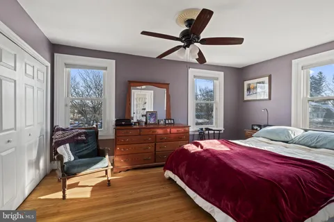 a bedroom with a bed and wooden floor