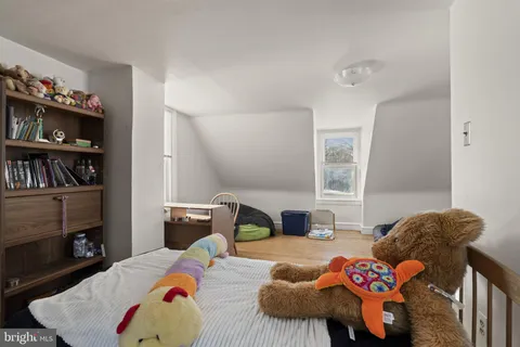 a bedroom with two beds and a book shelf