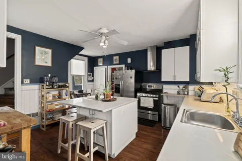 a kitchen with kitchen island granite countertop a sink appliances cabinets and furniture