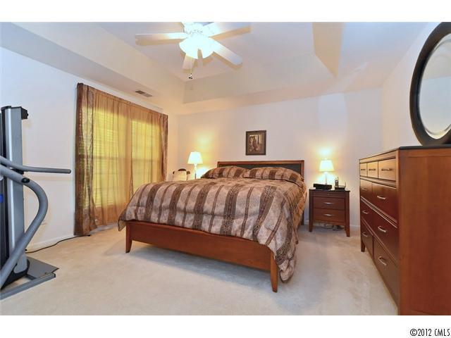 608 Eaton Court Fort Mill, SC 29708 - Photo 14 of 16 a bedroom with a bed a chandelier and dresser