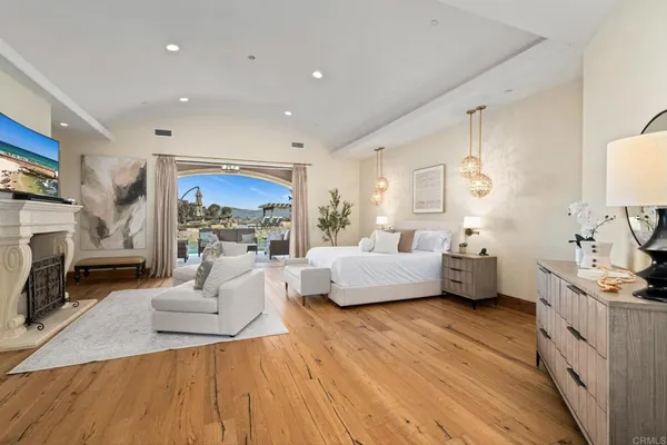 a spacious bedroom with a bed a couch and a large window