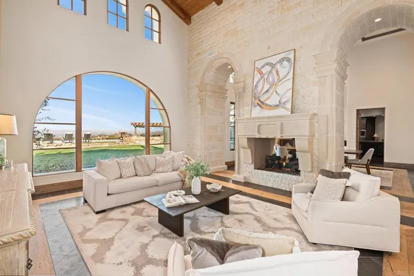 a living room with furniture fireplace and a large window