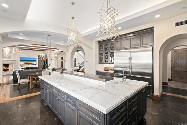 a large kitchen with kitchen island a large counter space a sink appliances and living room view