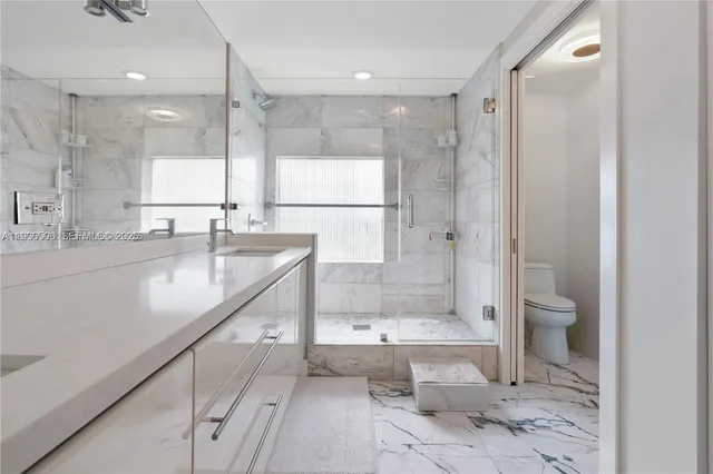 a bathroom with a granite countertop sink mirror bathtub and shower