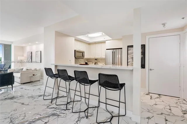 a kitchen with stainless steel appliances kitchen island granite countertop a refrigerator and cabinets