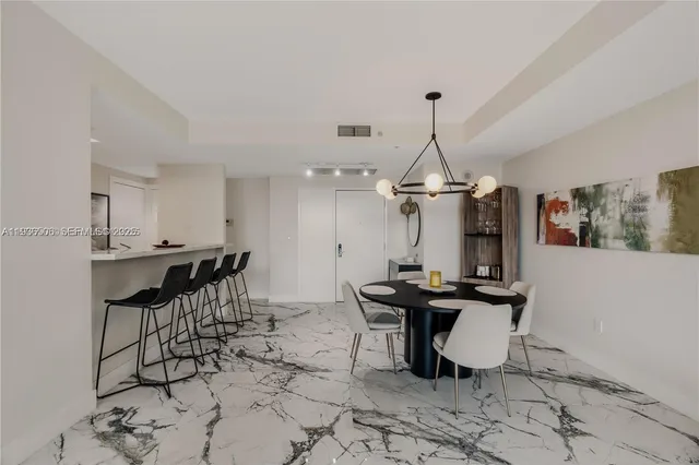 a view of a dining room with furniture and chandelier