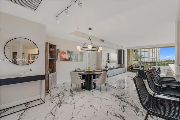 a view of a dining room with furniture a chandelier and wooden floor