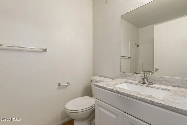 a bathroom with a granite countertop sink a toilet and a mirror