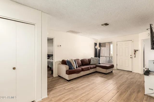 a living room with furniture and a wooden floor