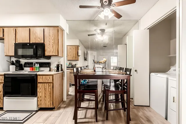 a kitchen with stainless steel appliances kitchen island granite countertop a table chairs and a refrigerator