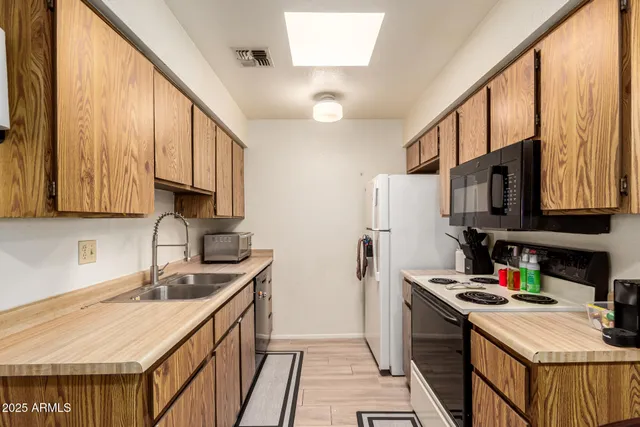 a kitchen with stainless steel appliances granite countertop a sink stove refrigerator and cabinets