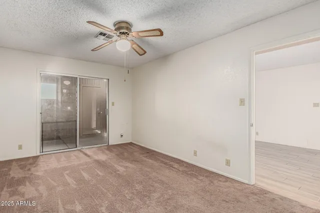 an empty room with closet and windows