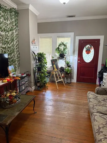 a living room with furniture and a wooden floor