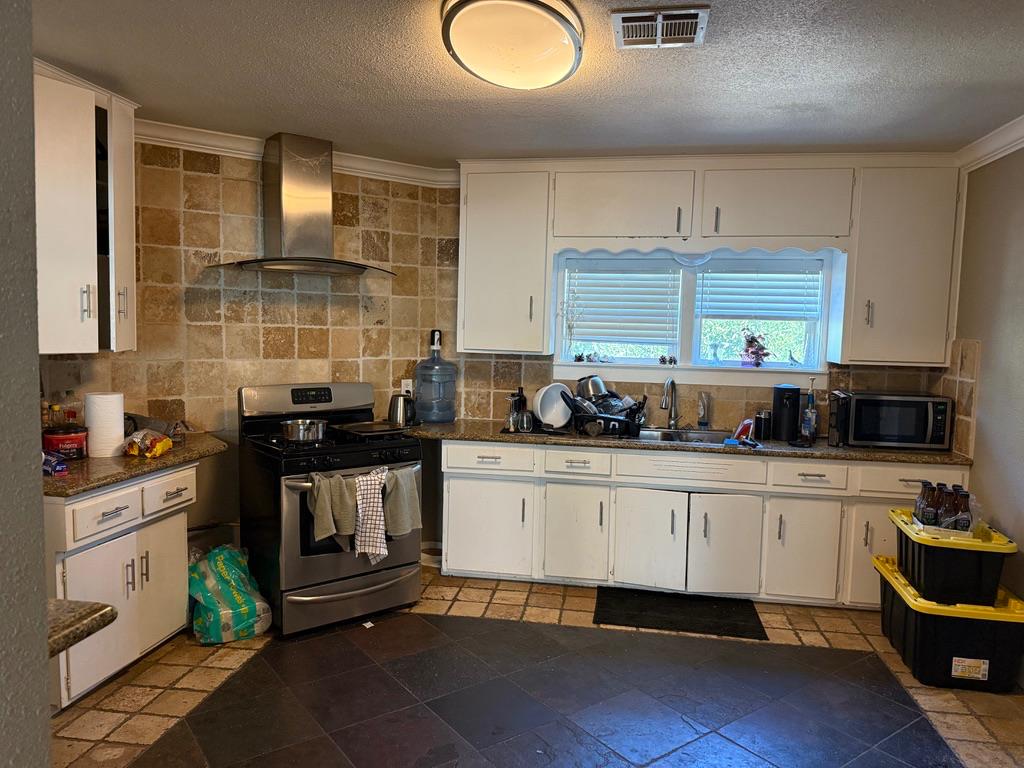 533 Reeves Avenue Yuba City, CA 95991 - Photo 16 of 48 a kitchen with granite countertop a stove a sink and a microwave