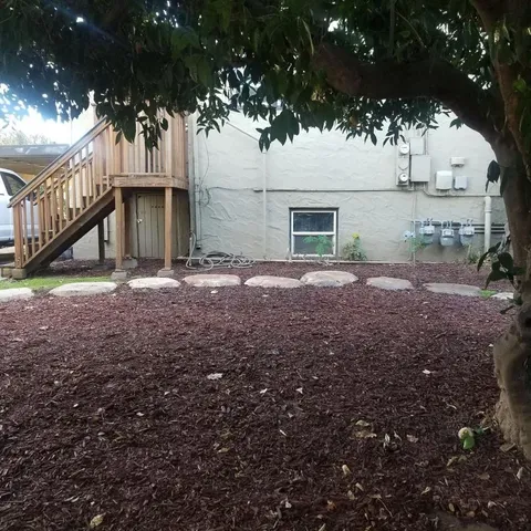 a view of a house with backyard and a tree