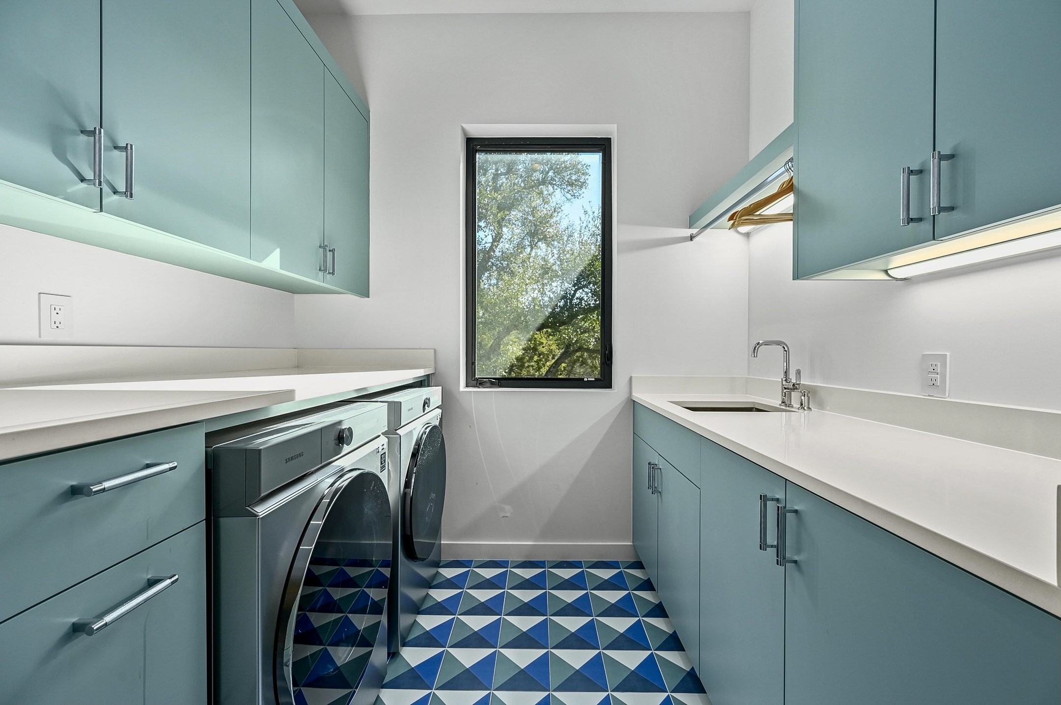 475 Happy Trail Dripping Springs, TX 78620 - Photo 17 of 40 Laundry room featuring blue cabinetry, white countertops, and a window providing natural light